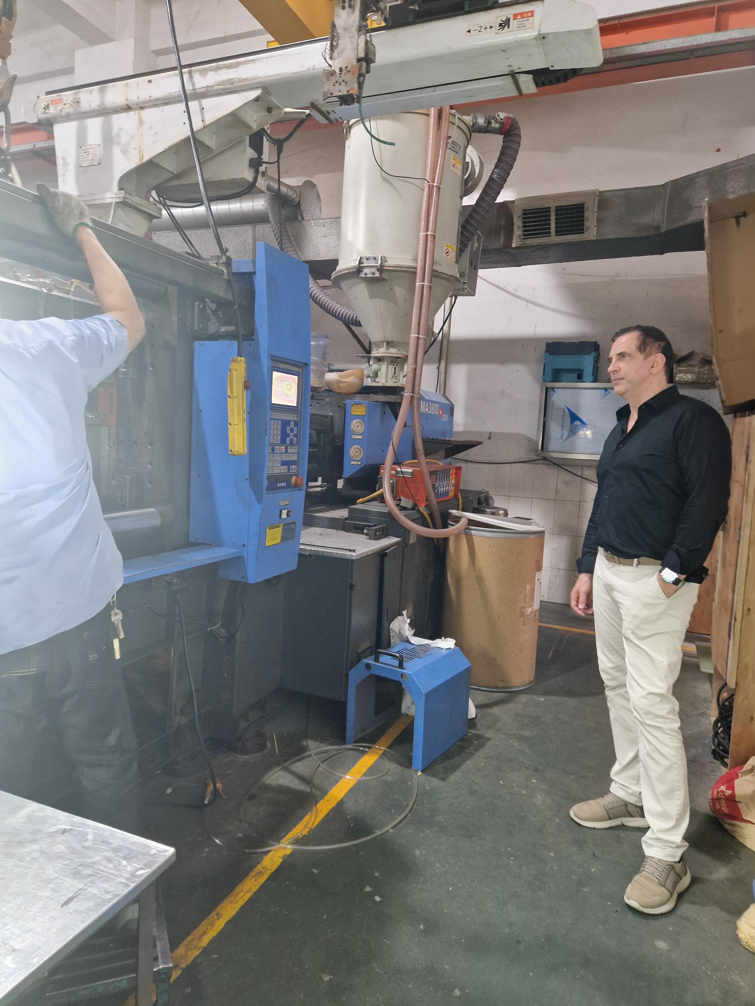 Inventus founder reviewing factory machinery during a production visit.