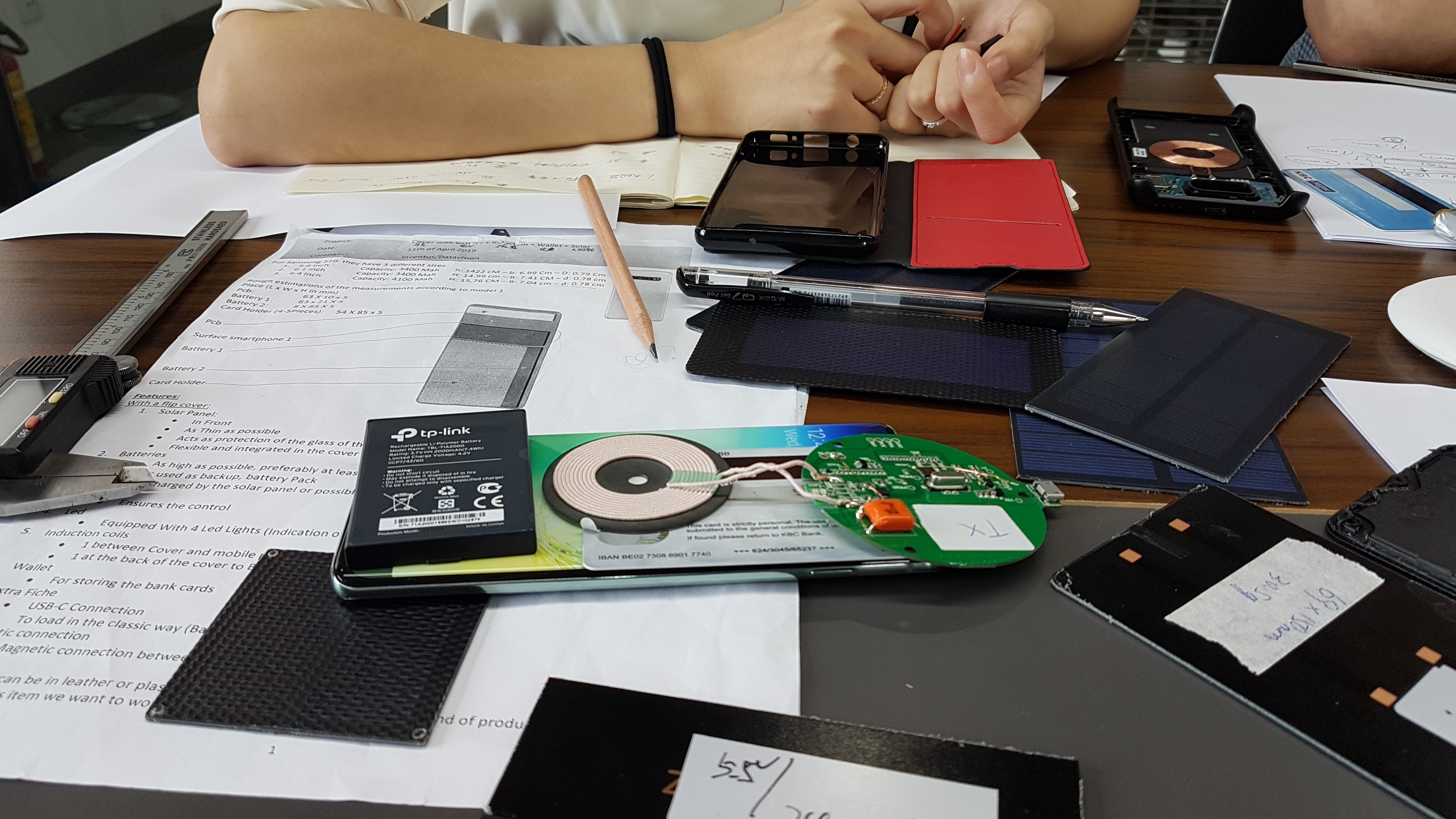Working session defining a product problem — components, sketches and dimensioned notes on the development table.